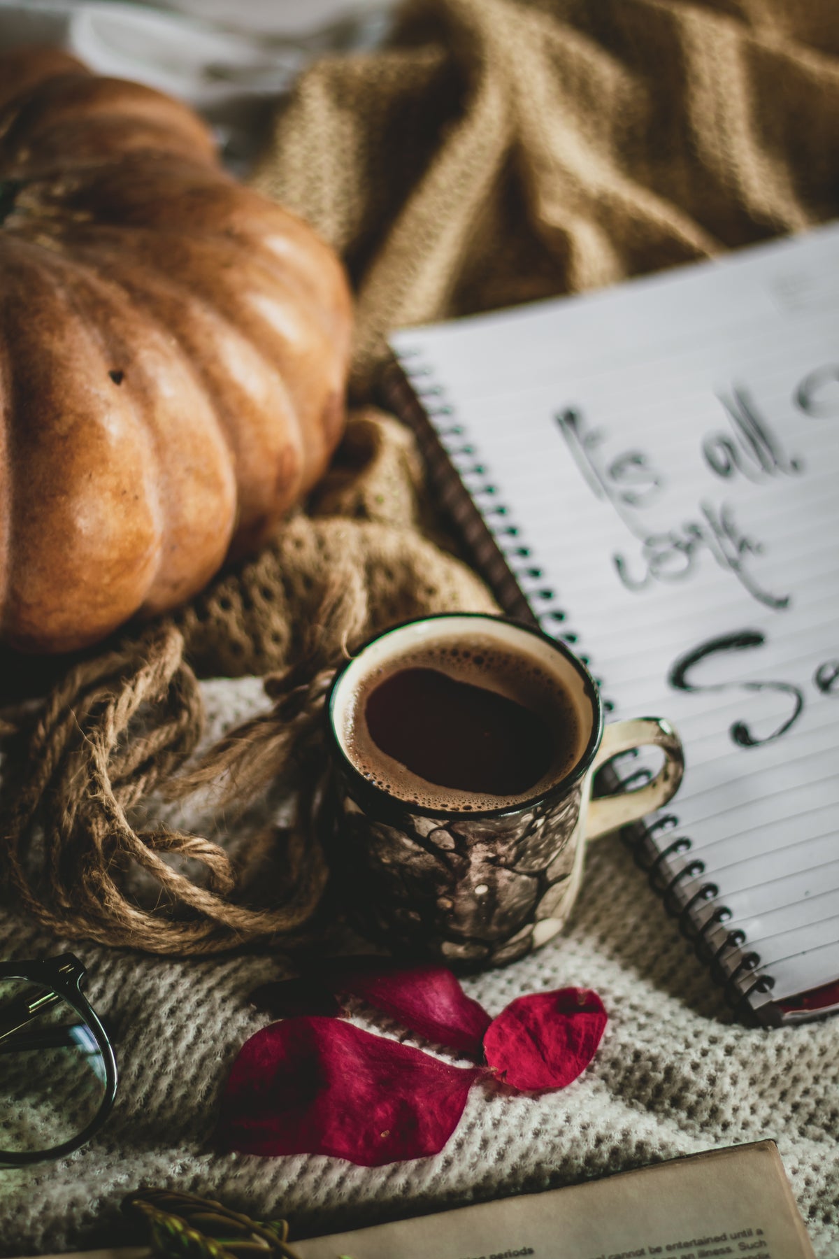 Tarot deck, crystals, a lit candle and a cup of hot tea with cinnamon and rosemary on an oak table by an open window, autumn trees outside