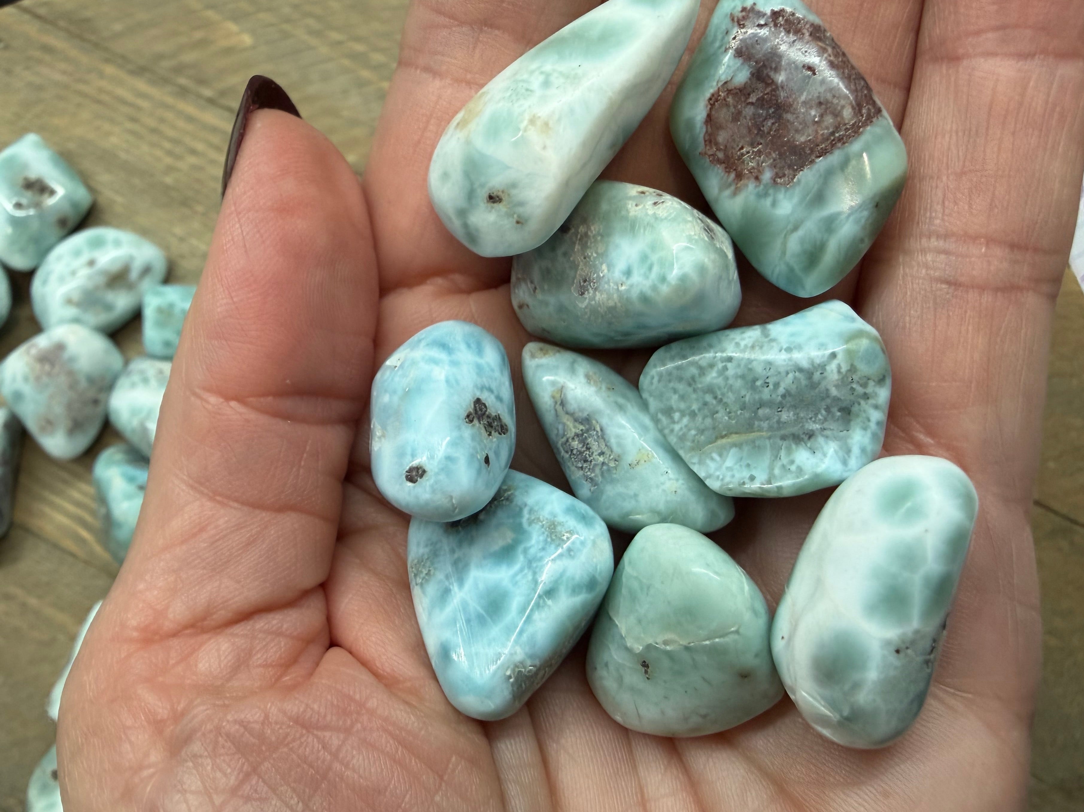Hand holding a collection of turquoise stones with a blurred background