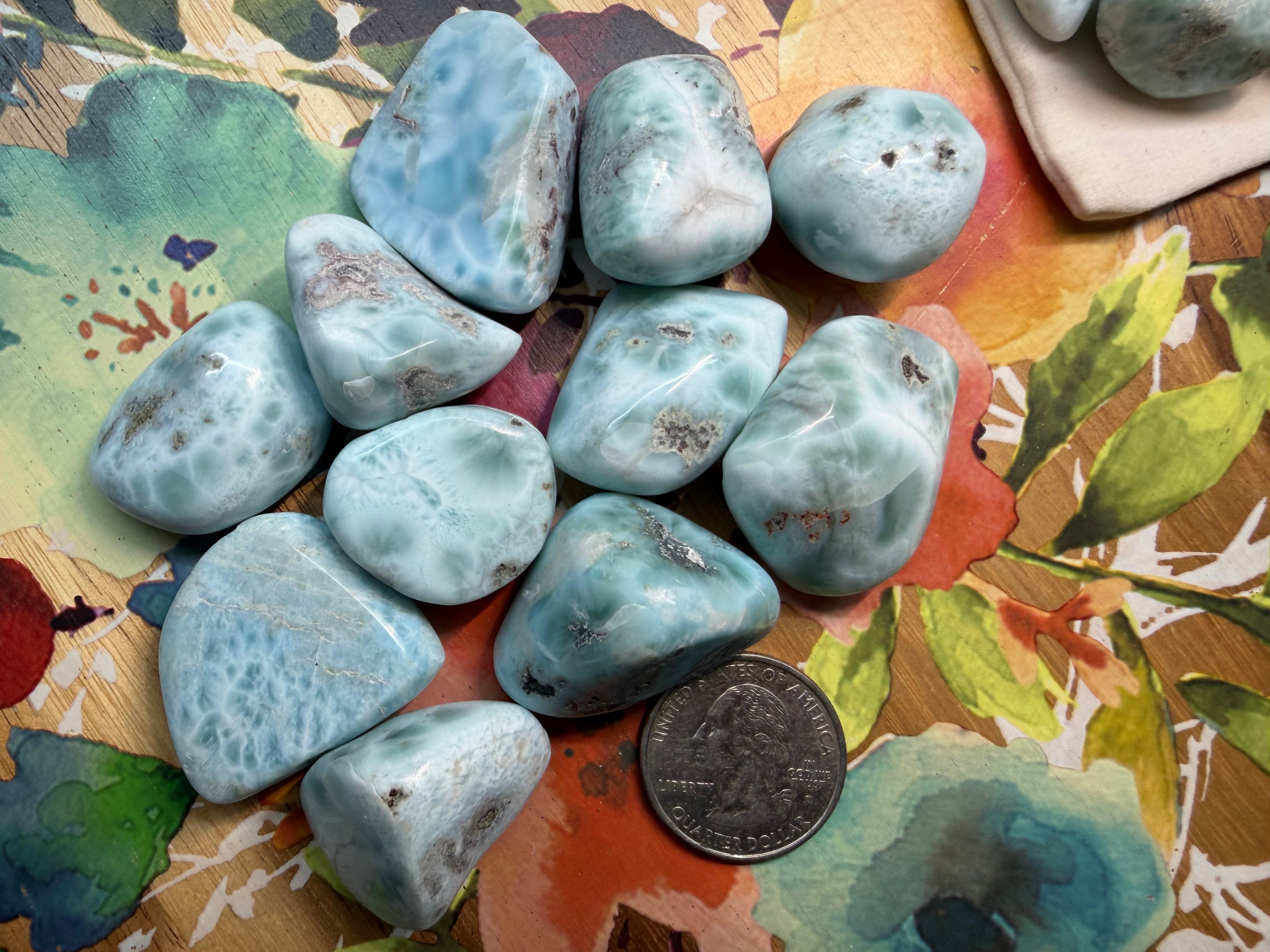 Collection of blue-green stones on a colorful fabric background