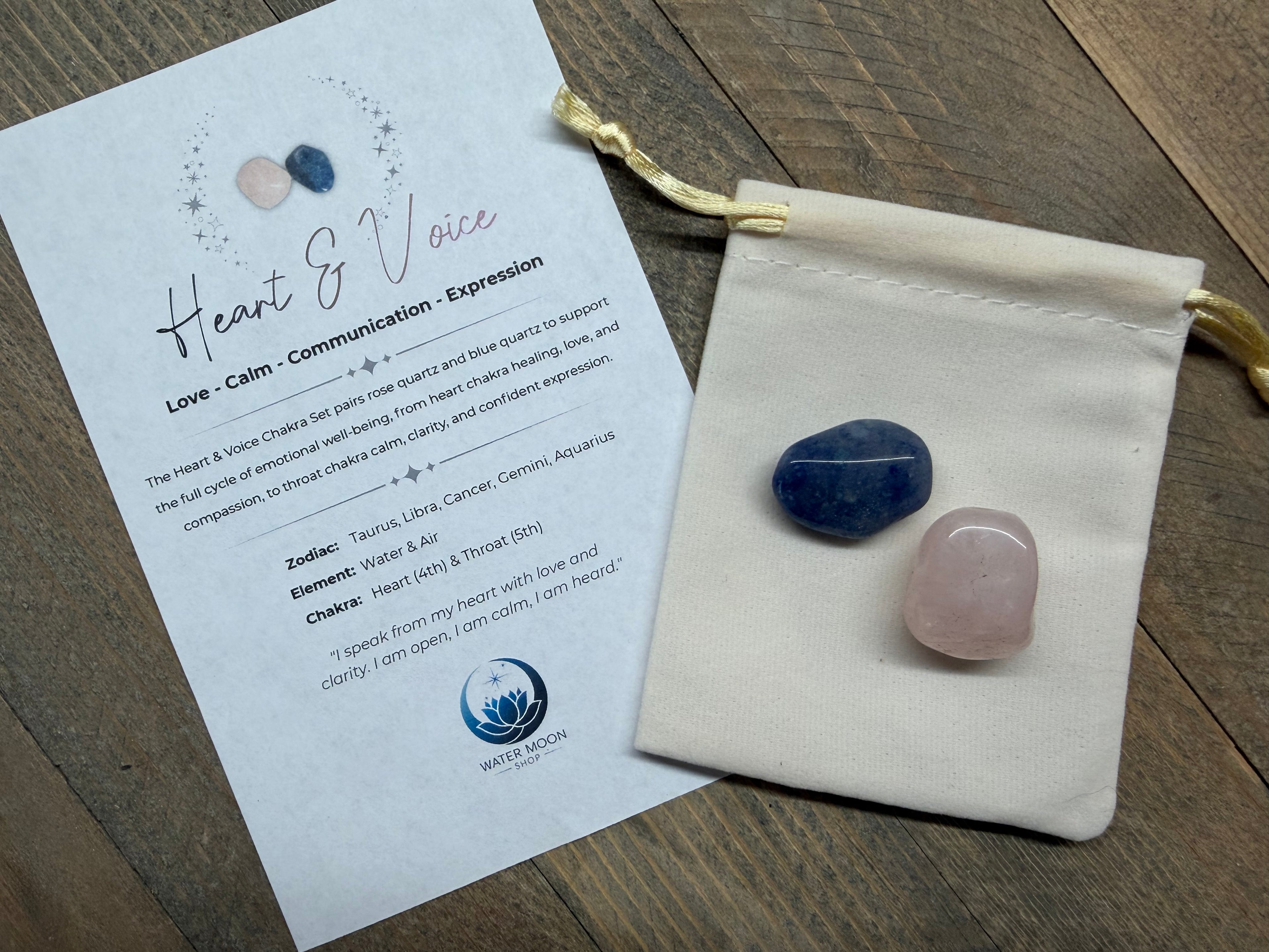 Two stones in a drawstring bag with an informational card on a wooden surface