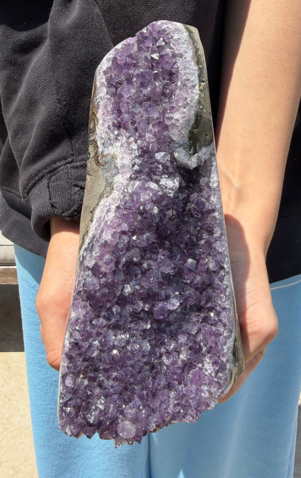Person holding a large amethyst crystal
