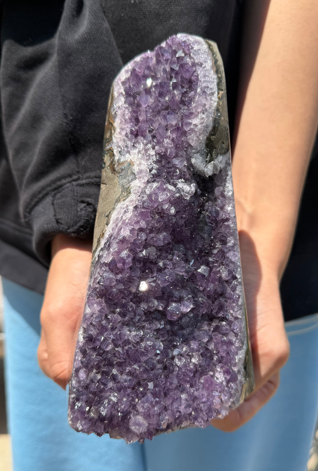 Person holding a large amethyst crystal