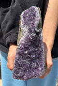 Person holding a large amethyst crystal