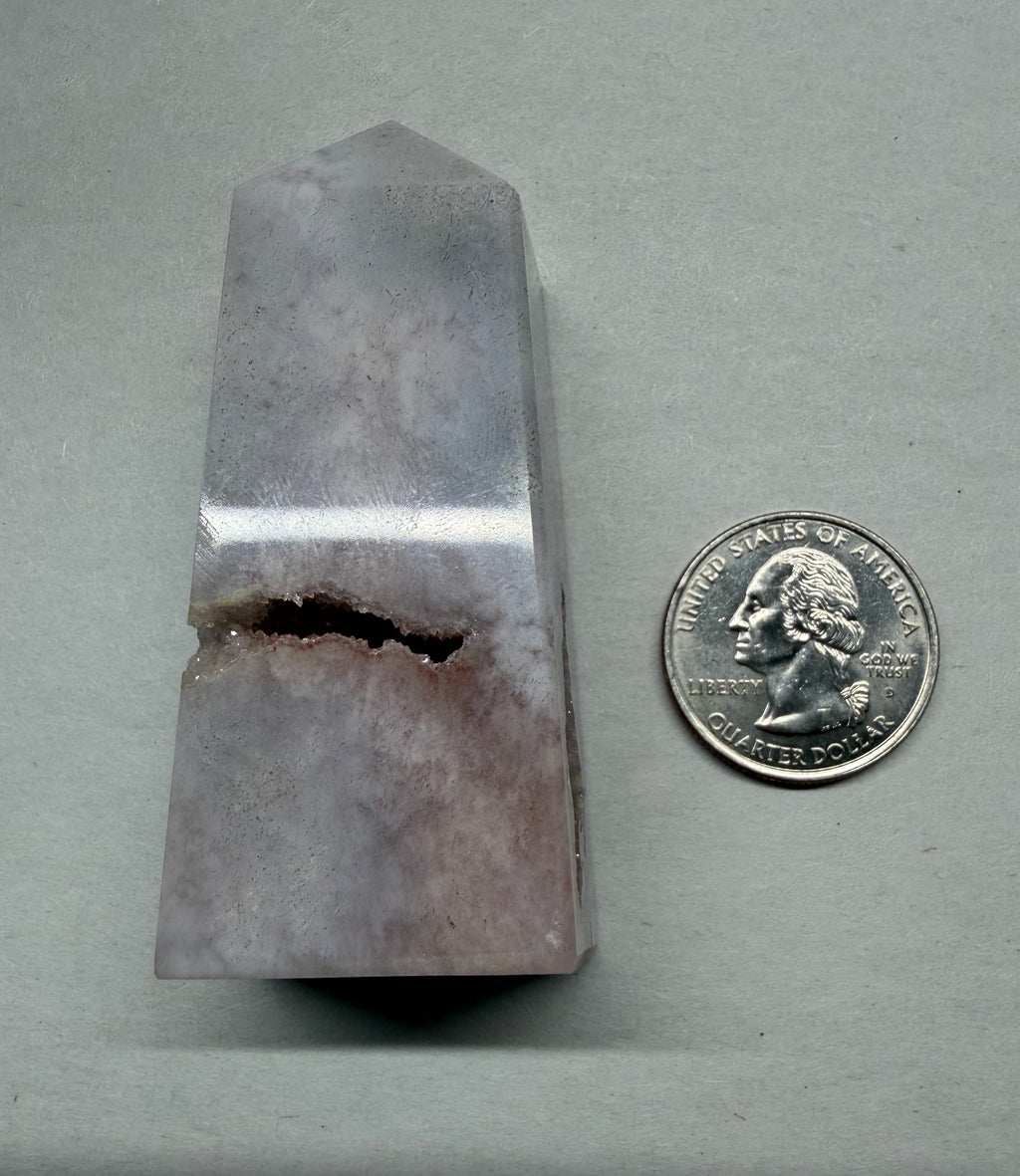 Crystal prism next to a U.S. quarter on a gray background