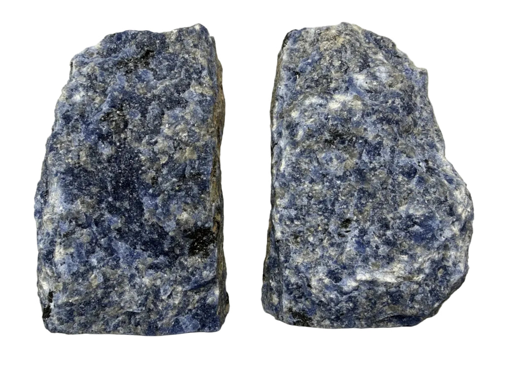 Two rough blue and white speckled stone blocks, likely lapis lazuli or similar mineral specimens, displayed side by side on a light beige background.