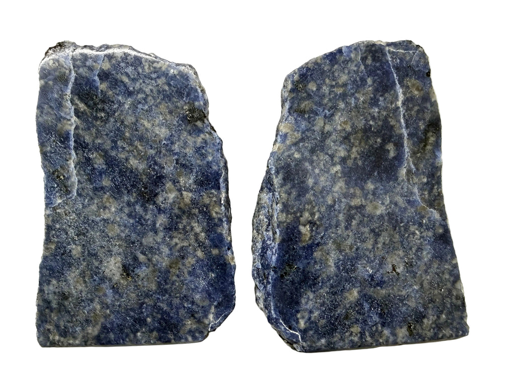 Two Sodalite Crystal specimens with naturally fractured edges, showing deep blue and white speckled patterns, displayed side-by-side on a light beige background.
