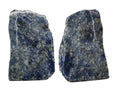 Two Sodalite Crystal specimens with naturally fractured edges, showing deep blue and white speckled patterns, displayed side-by-side on a light beige background.