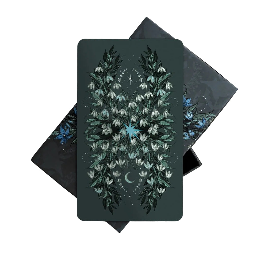 Card with floral design on a dark background surrounded by foliage