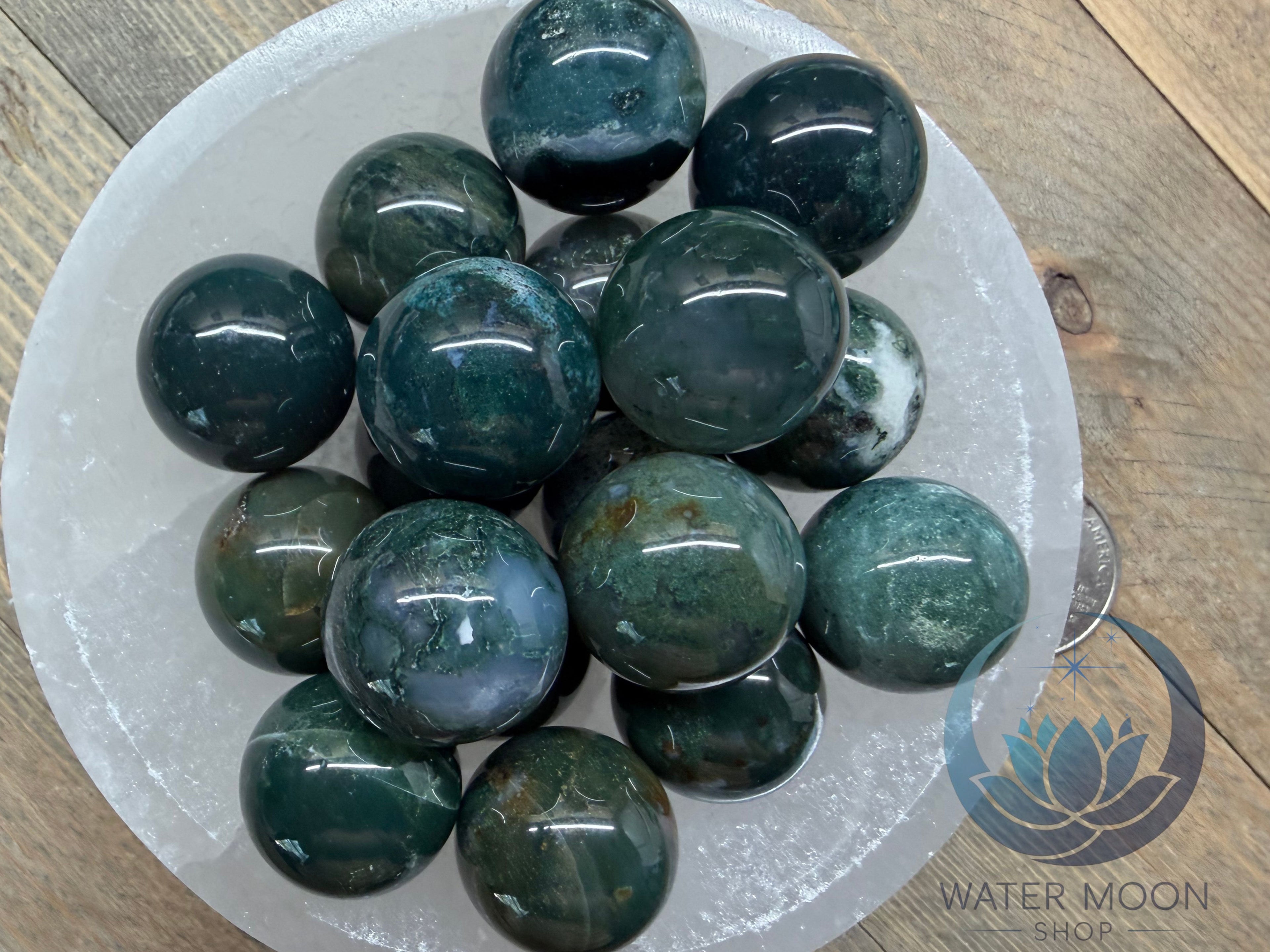 Green marbles on a white plate with Water Moon logo in the corner