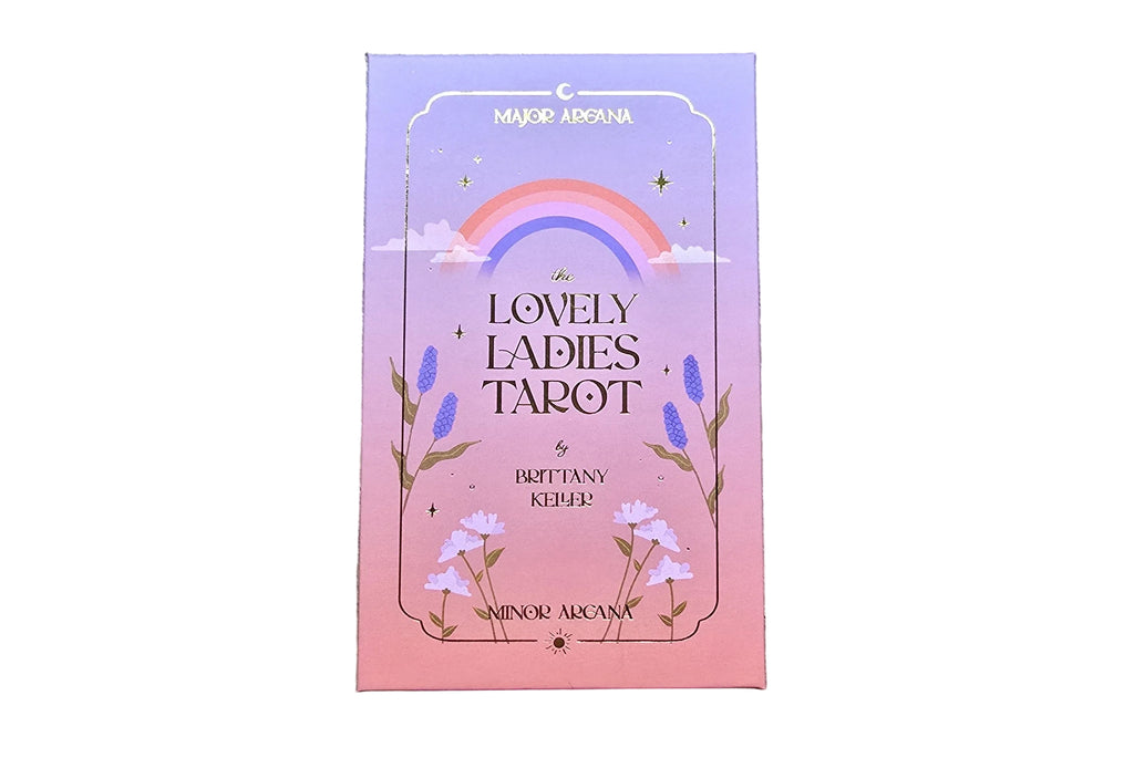 Card deck packaging with a rainbow and floral design on a wooden surface