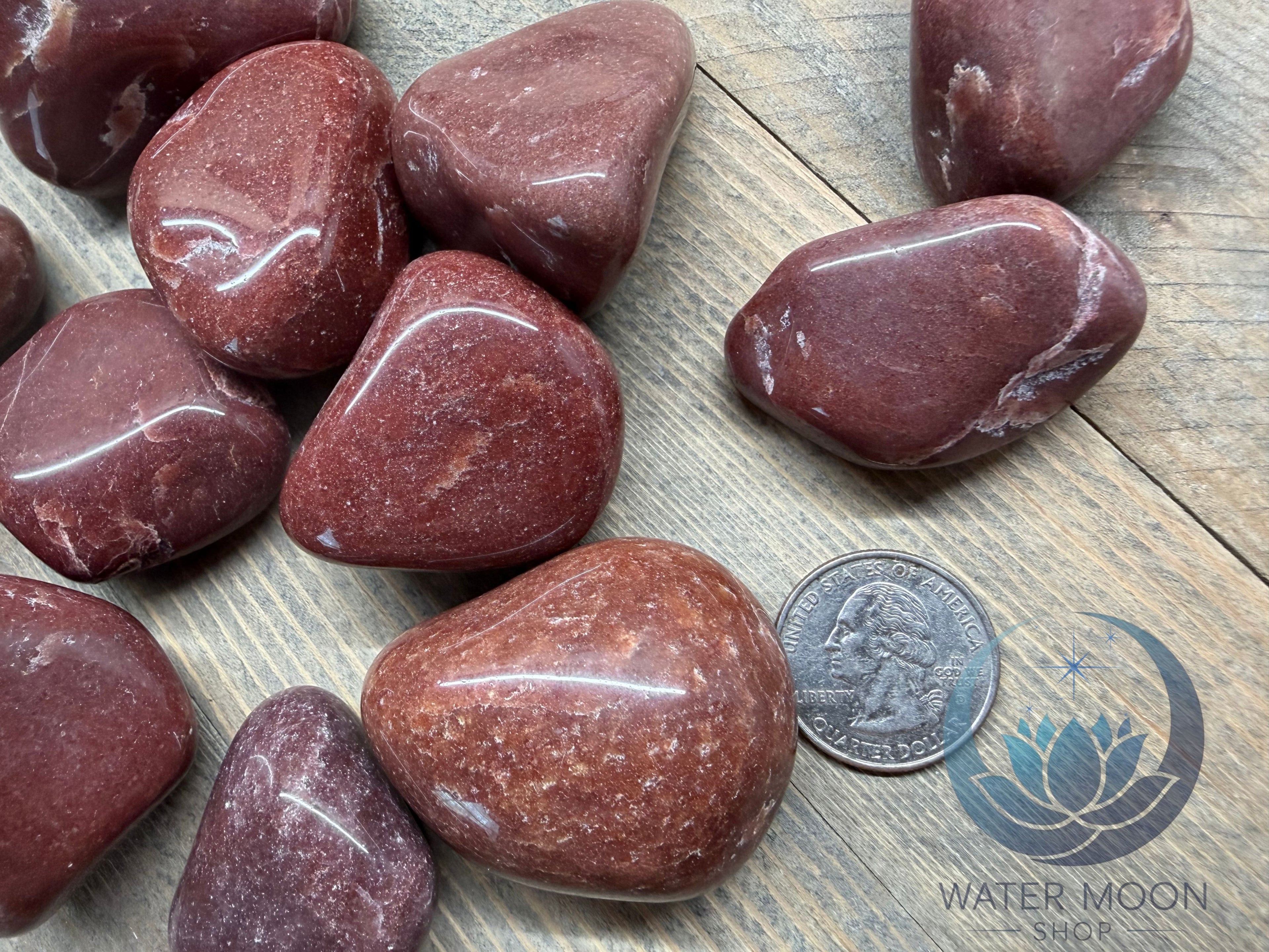 Red stones on a wooden surface with a coin for scale