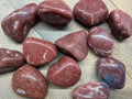 Red marbled stones on a wooden surface