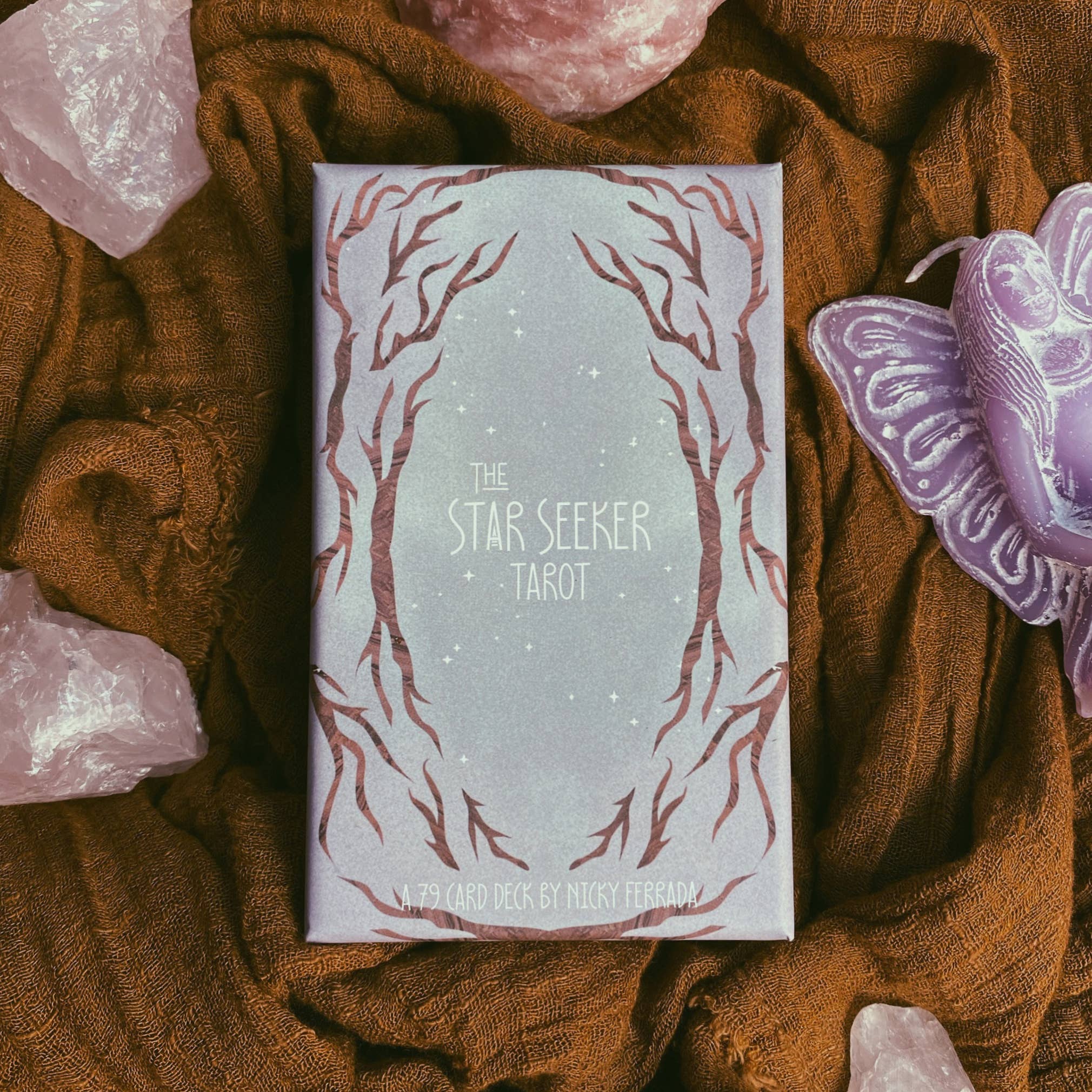 Star Seeker Tarot box on a textured brown fabric background with crystals and a butterfly.